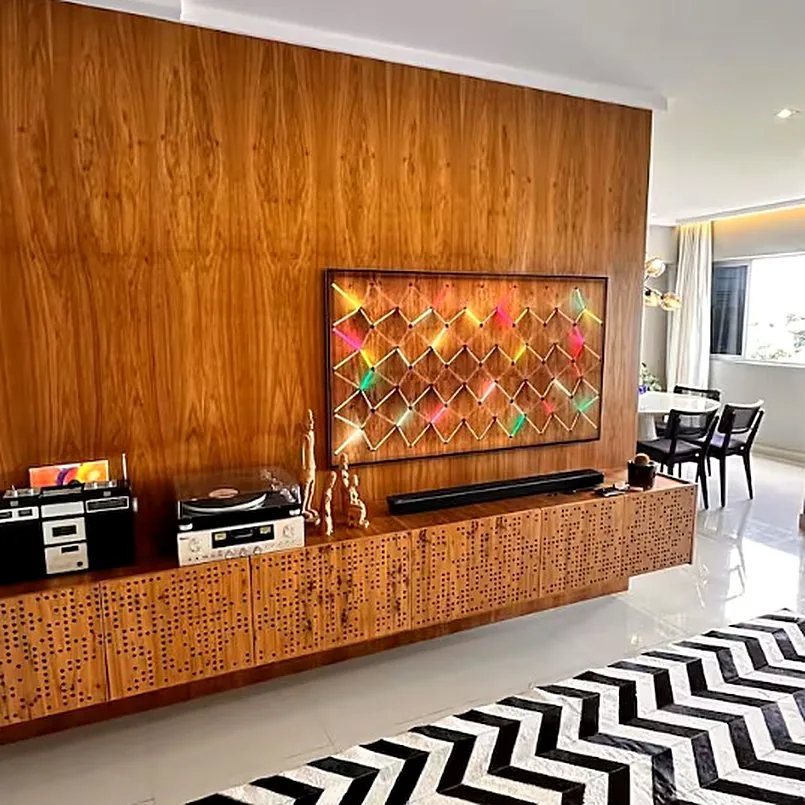Sala de estar com painel de madeira, toca-discos e tapete chevron preto e branco