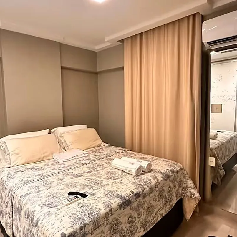 Suíte master com cama queen e cortinas